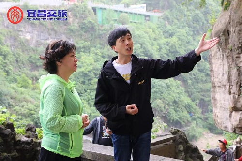 圖為向?。ㄗ蠖檠胍曋破?、主持人鞠萍（左一）介紹三游洞景區(qū)